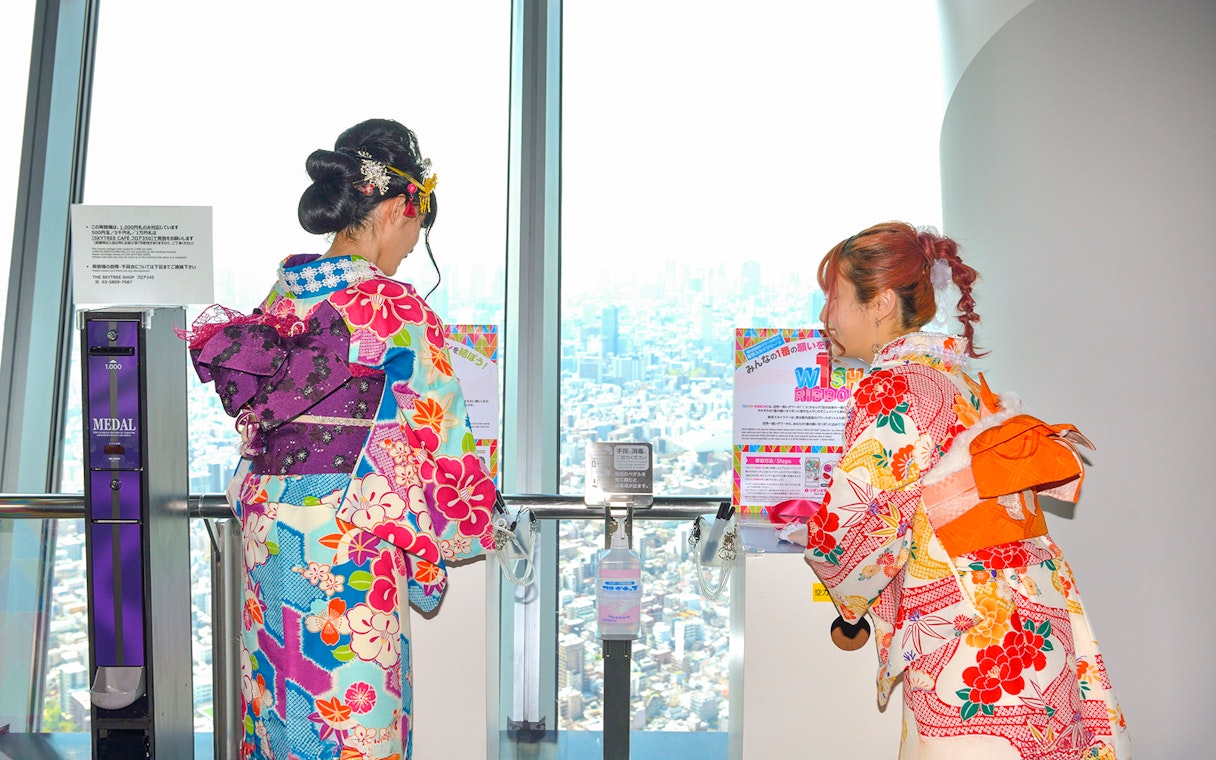 Visitors in colorful kimonos enjoying the view from Tokyo Skytree observation deck.