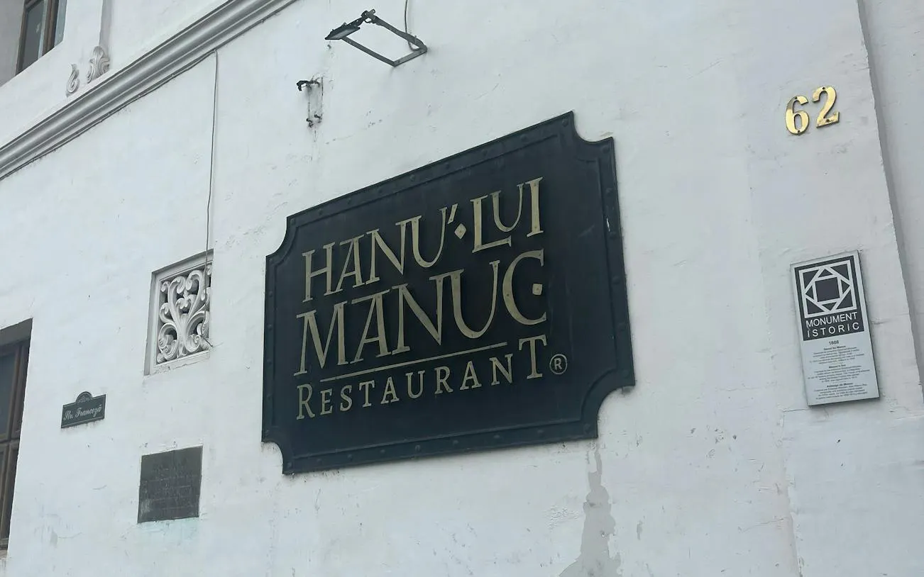 Hanu' lui Manuc restaurant sign on a historic building in Bucharest.