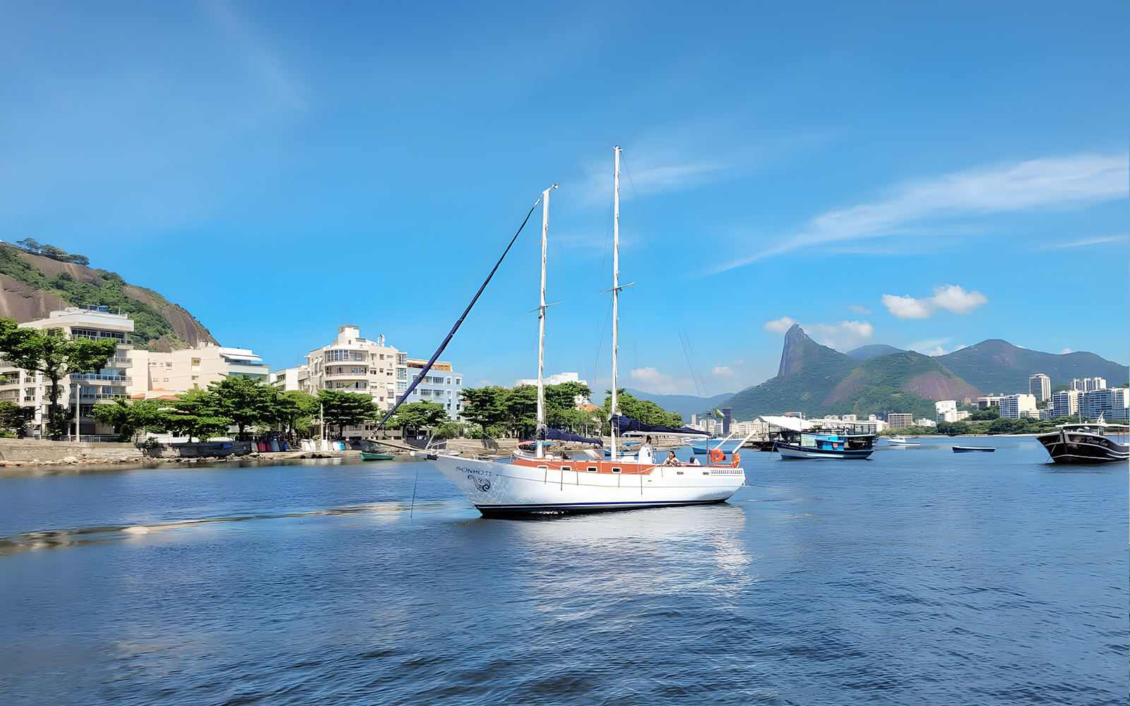 Tourist on sailboat with view of Rio de Janeiro's Sugarloaf Mountain.