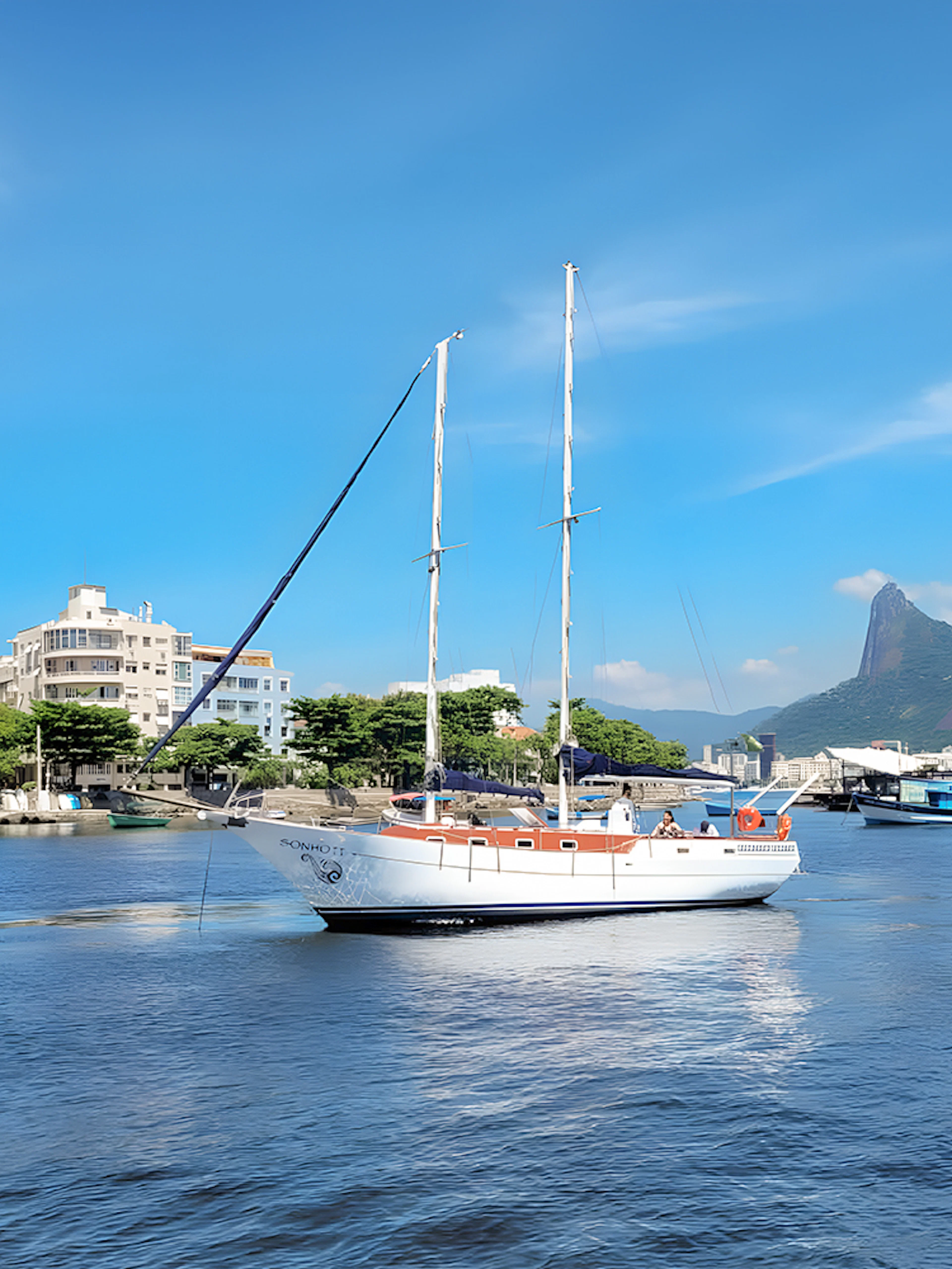 Tourist on sailboat with view of Rio de Janeiro's Sugarloaf Mountain.