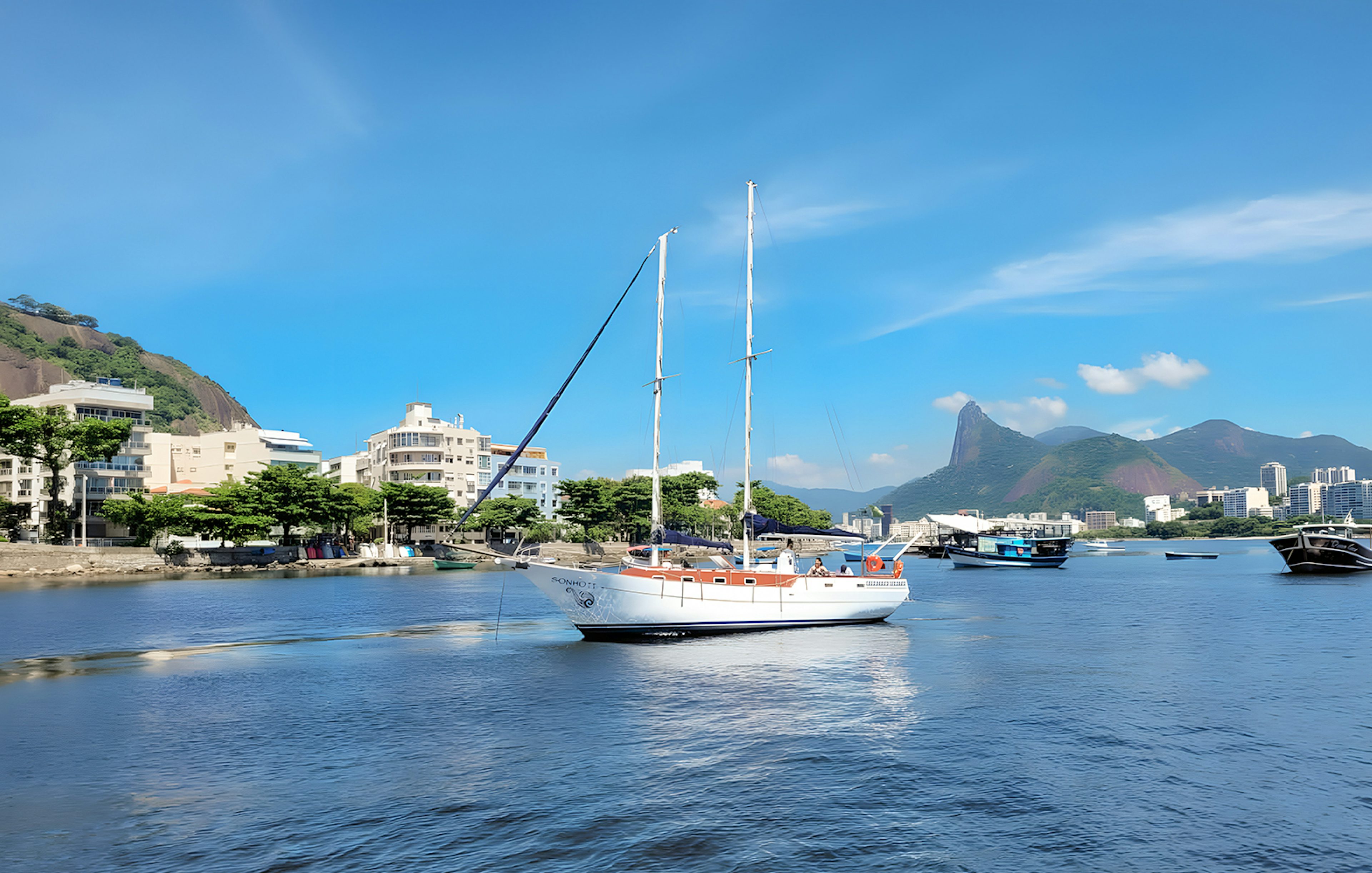 Tourist on sailboat with view of Rio de Janeiro's Sugarloaf Mountain.