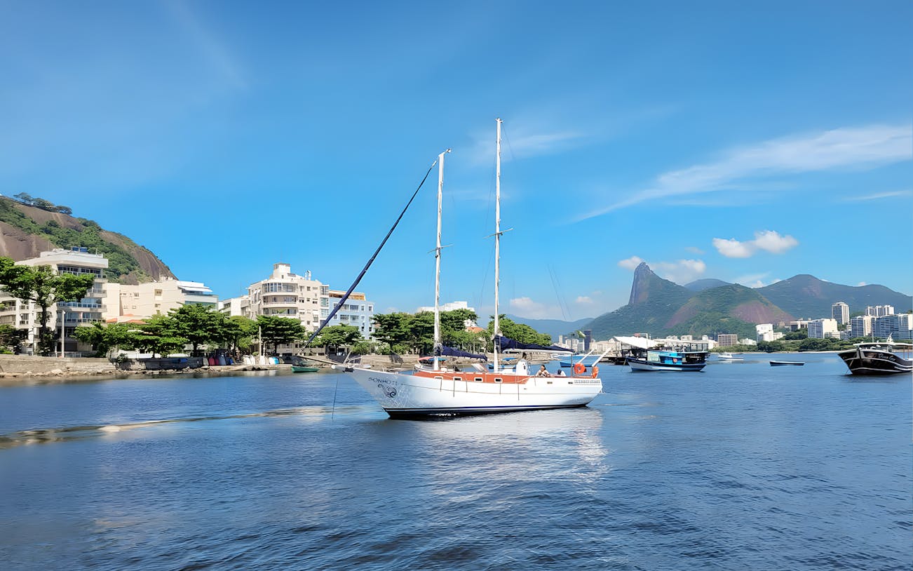 Tourist on sailboat with view of Rio de Janeiro's Sugarloaf Mountain.