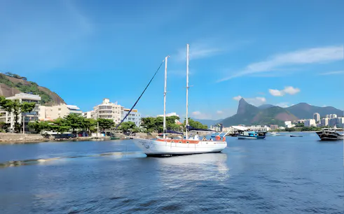 Tourist on sailboat with view of Rio de Janeiro's Sugarloaf Mountain.