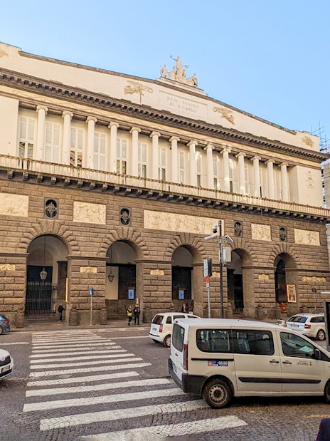 Naples Royal Palace exterior with cars and pedestrians in the monumental district.