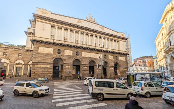 Naples Royal Palace exterior with cars and pedestrians in the monumental district.