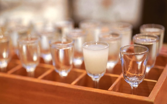 Sake glasses arranged for tasting at a Kyoto brewery tour.