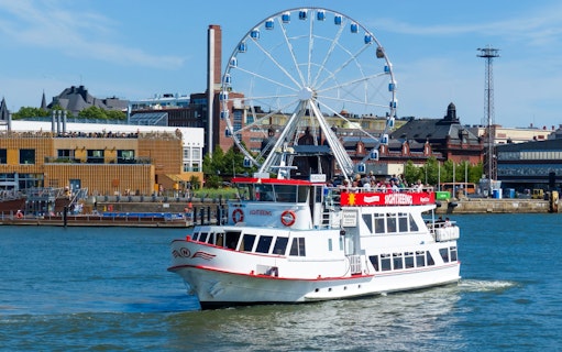 Guests on a sightseeing ship near a Ferris wheel in Helsinki, Finland.