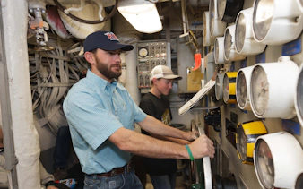 Men operating machinery during a guided engineering tour.