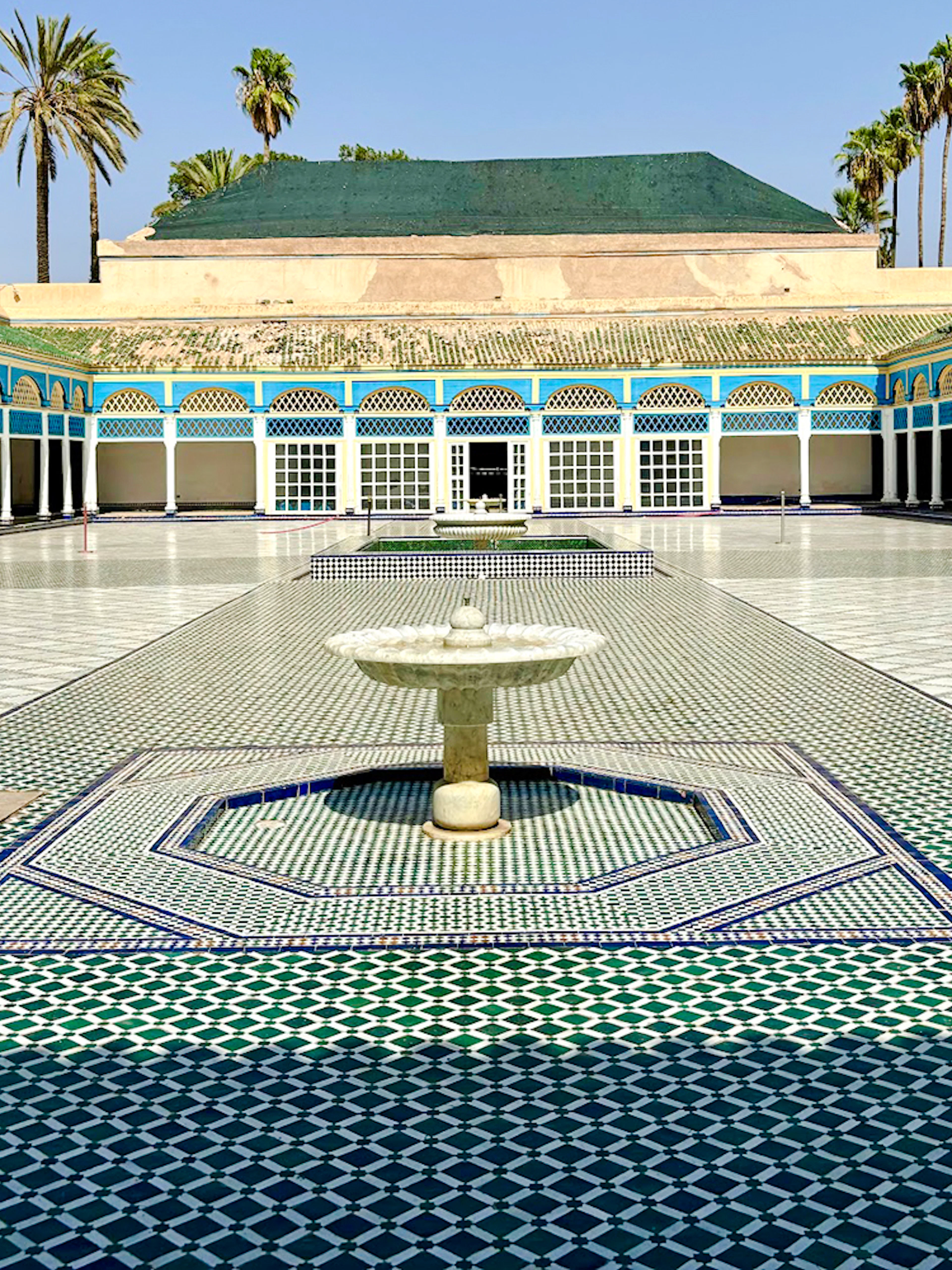 Bahia Palace courtyard with fountain and colorful tilework in Marrakech, Morocco.