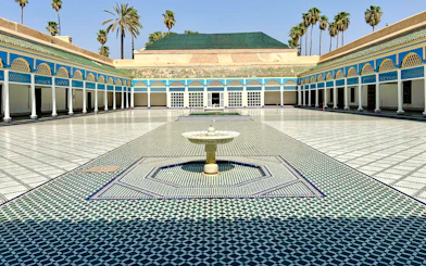 Bahia Palace courtyard with fountain and colorful tilework in Marrakech, Morocco.