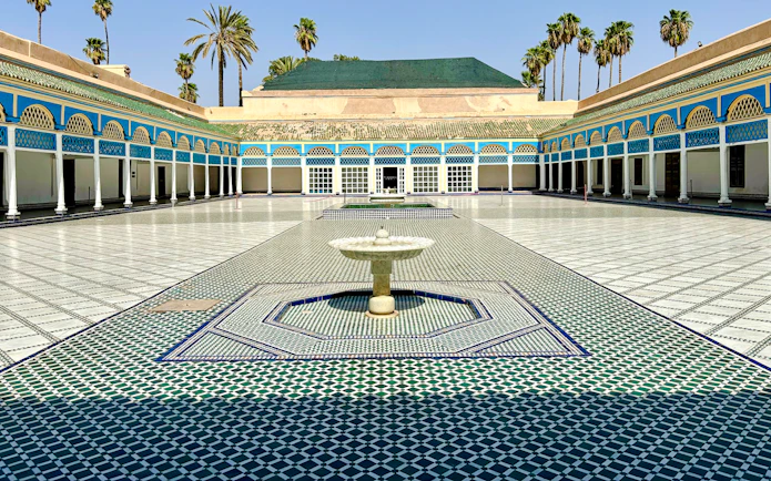 Bahia Palace courtyard with fountain and colorful tilework in Marrakech, Morocco.