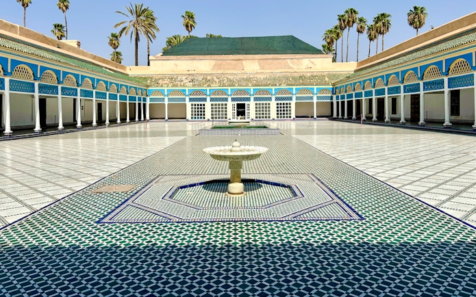 Bahia Palace courtyard with fountain and colorful tilework in Marrakech, Morocco.