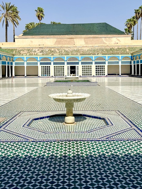 Bahia Palace courtyard with fountain and colorful tilework in Marrakech, Morocco.