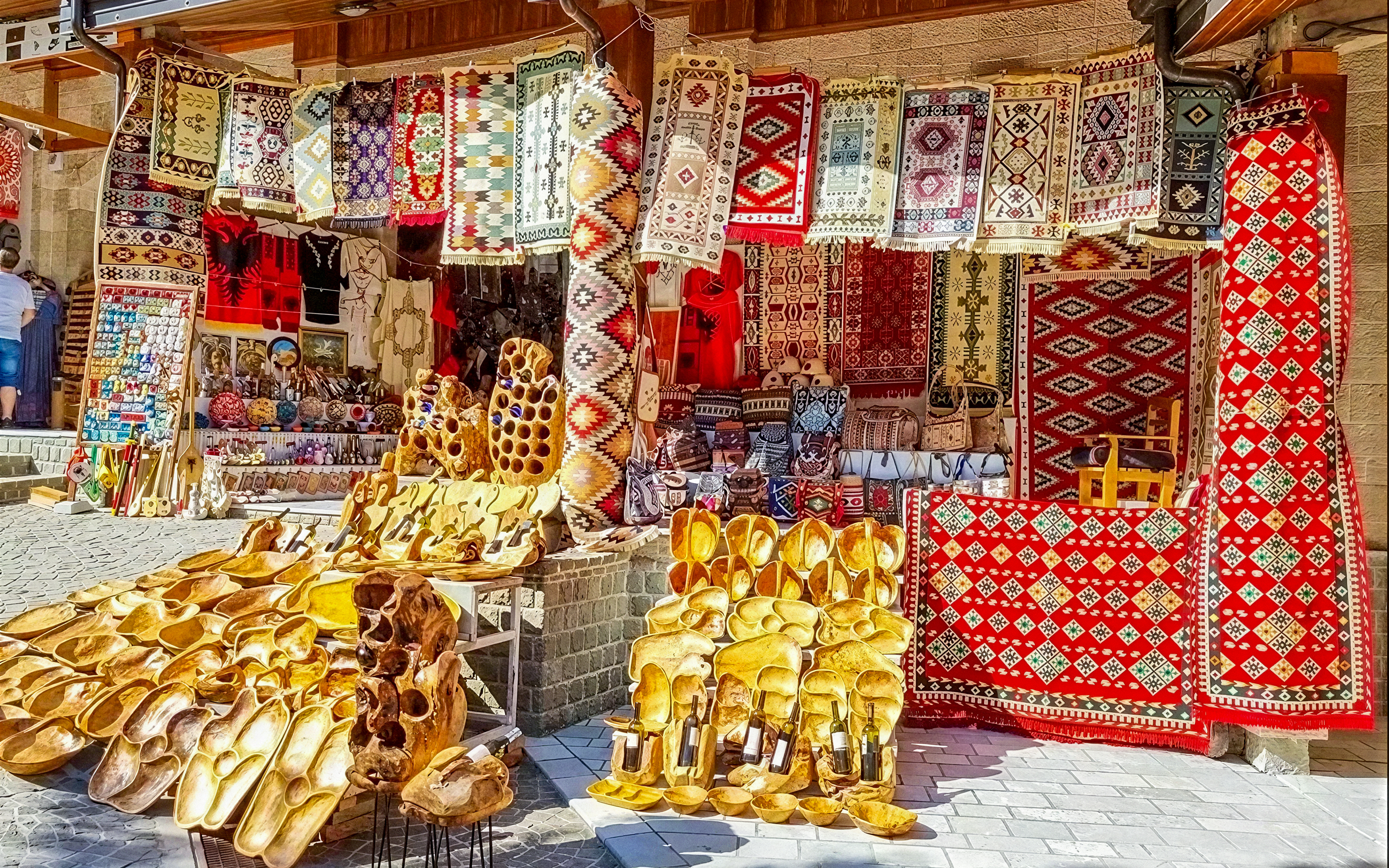 Colorful rugs and wooden crafts displayed at Old Bazaar, Kruje city, Albania.