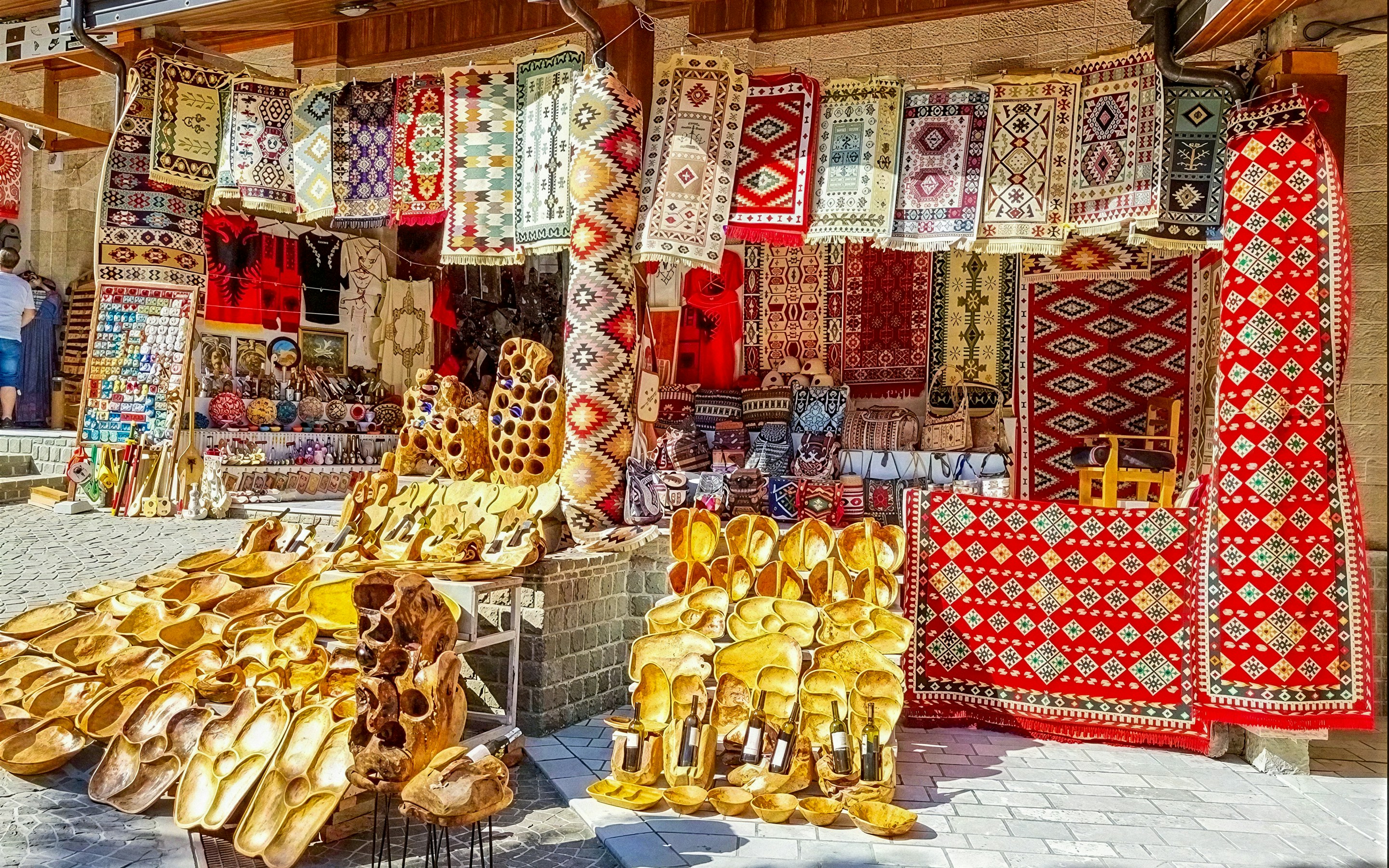 Colorful rugs and wooden crafts displayed at Old Bazaar, Kruje city, Albania.