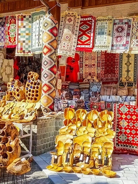 Colorful rugs and wooden crafts displayed at Old Bazaar, Kruje city, Albania.