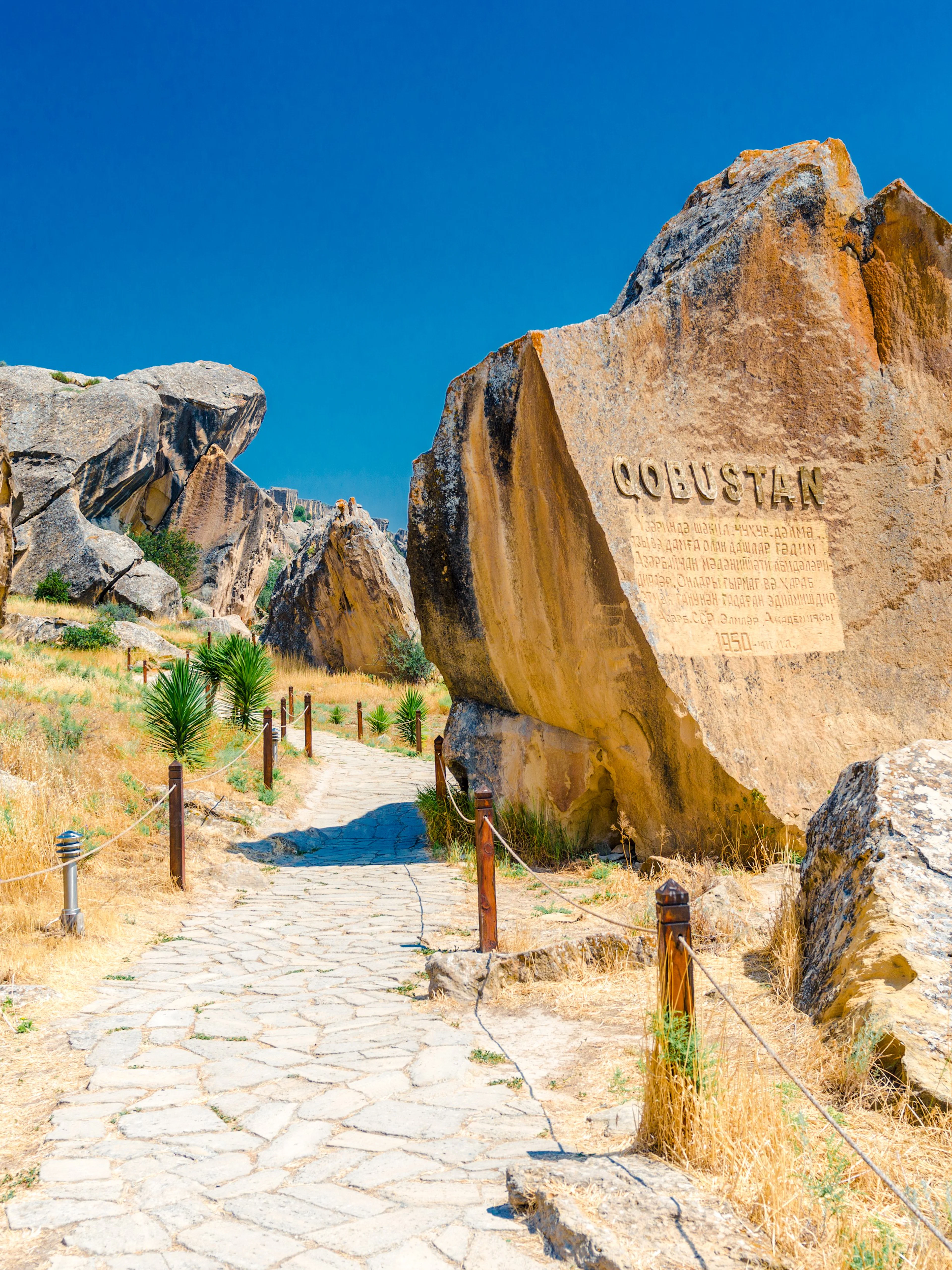 Gobustan park reserve in Azerbaijan with ancient rock petroglyphs and stone path.