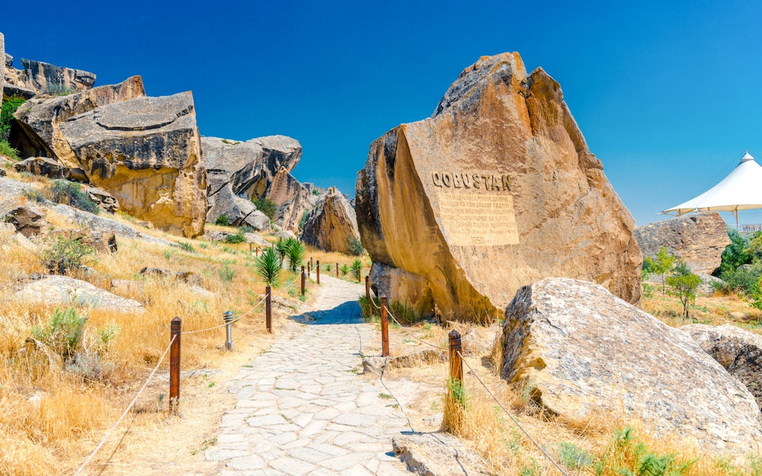 Gobustan park reserve in Azerbaijan with ancient rock petroglyphs and stone path.