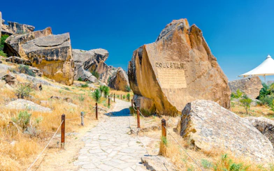 Gobustan park reserve in Azerbaijan with ancient rock petroglyphs and stone path.