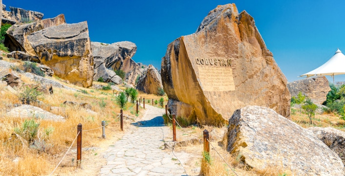Gobustan park reserve in Azerbaijan with ancient rock petroglyphs and stone path.