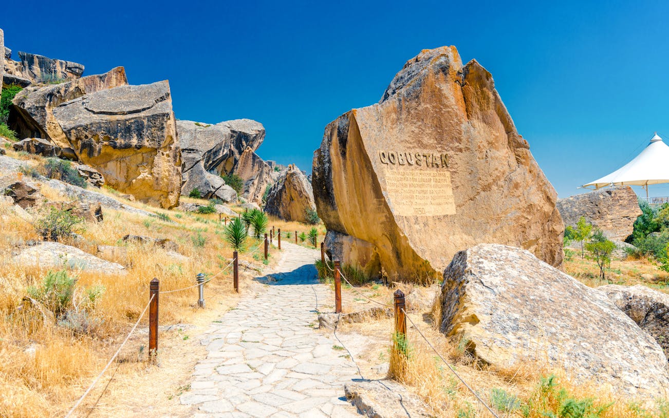 Gobustan park reserve in Azerbaijan with ancient rock petroglyphs and stone path.