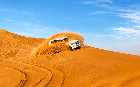 Dune bashing in a 4x4 vehicle on a Dubai desert safari.