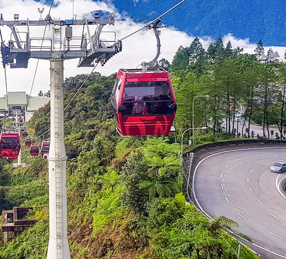 Genting Highlands cable car ascending through lush green hills.