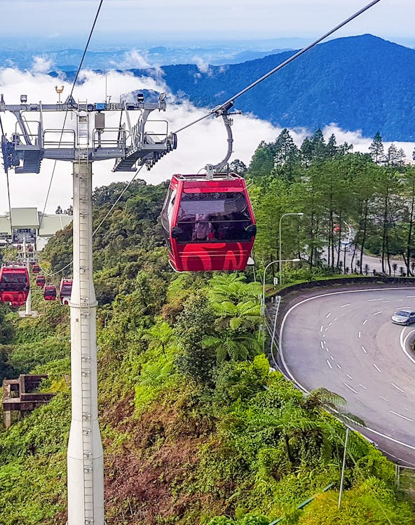 Genting Highlands cable car ascending through lush green hills.