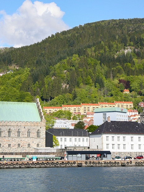 Bergen waterfront with historic buildings and green hills in the background.