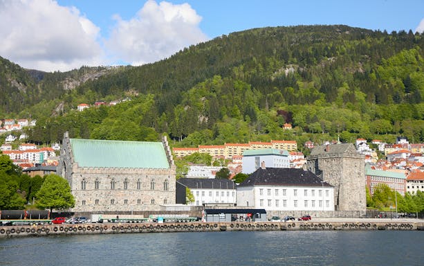Bergen waterfront with historic buildings and green hills in the background.