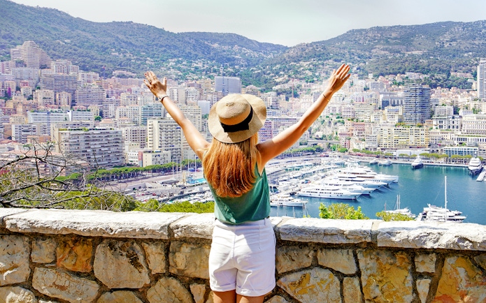 Tourist overlooking Monte Carlo harbor and cityscape in Monaco.