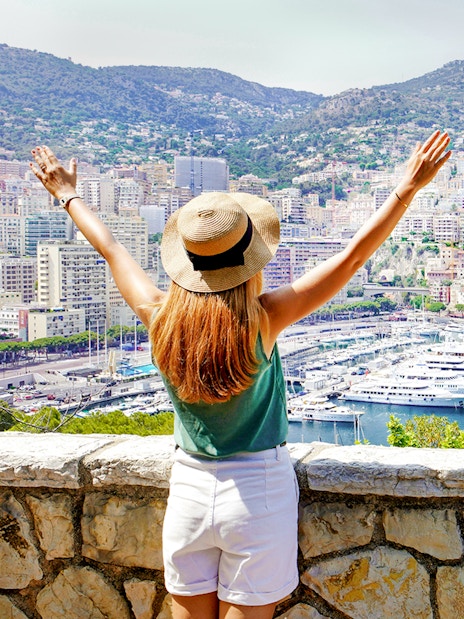 Tourist overlooking Monte Carlo harbor and cityscape in Monaco.