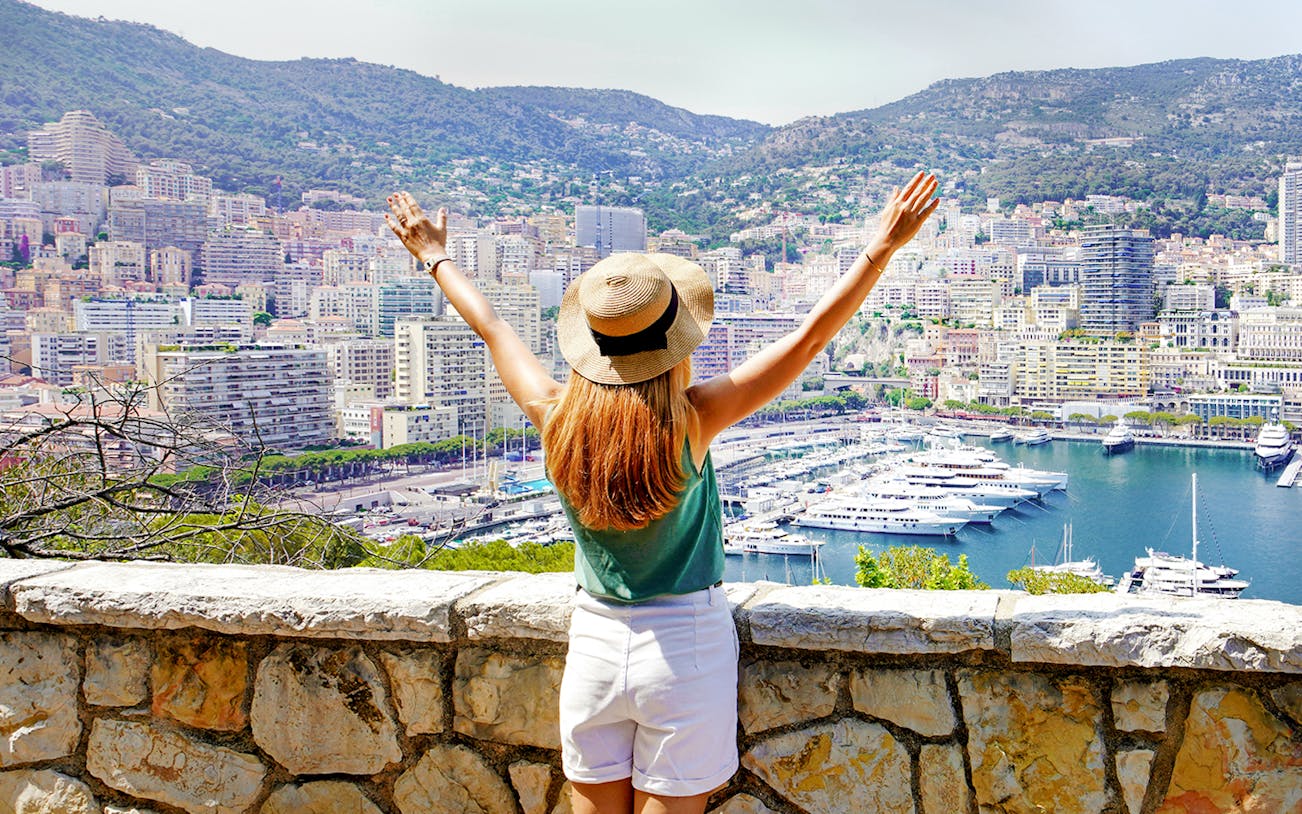 Tourist overlooking Monte Carlo harbor and cityscape in Monaco.