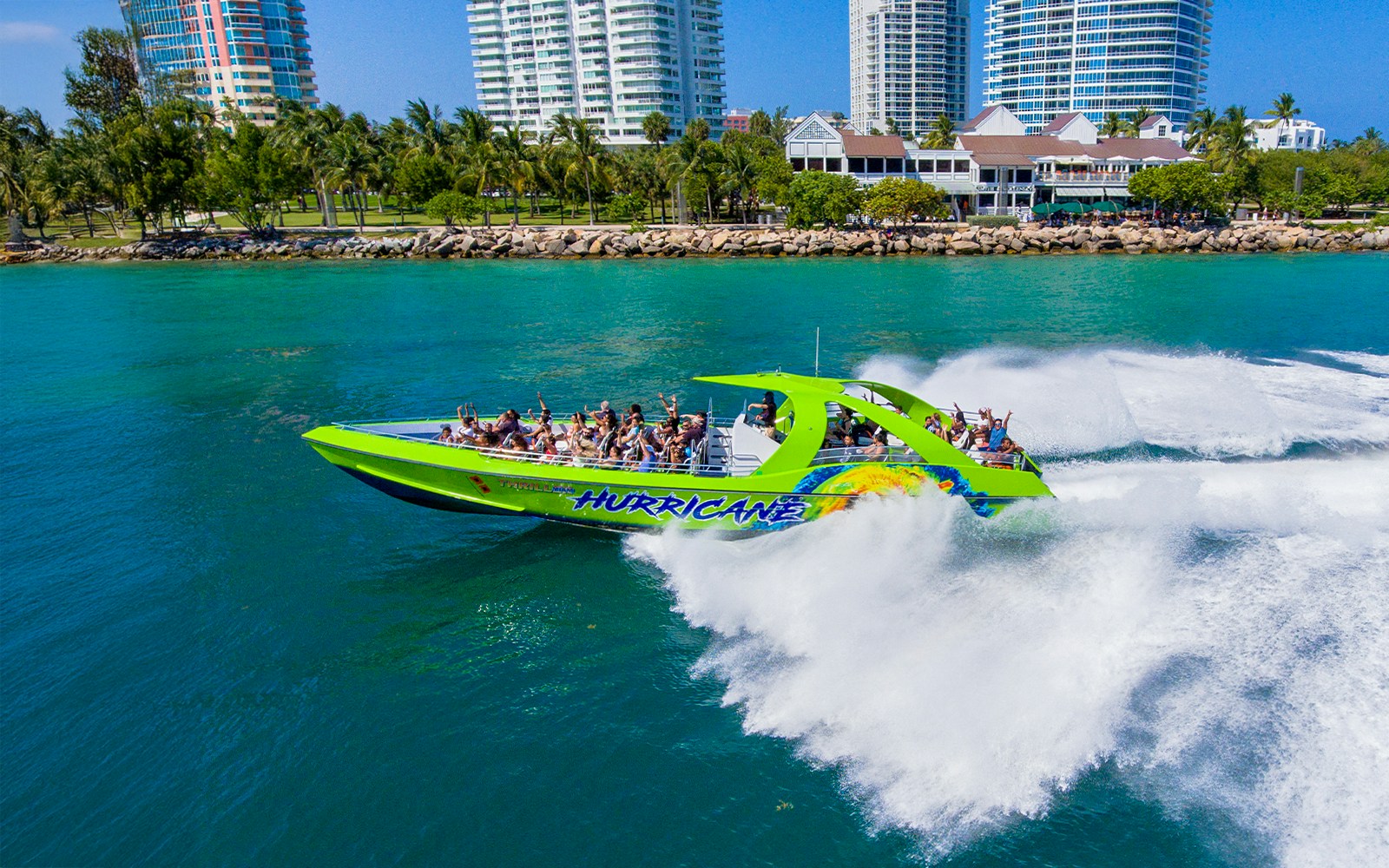 Speedboat cruising past Miami skyline on sightseeing tour.