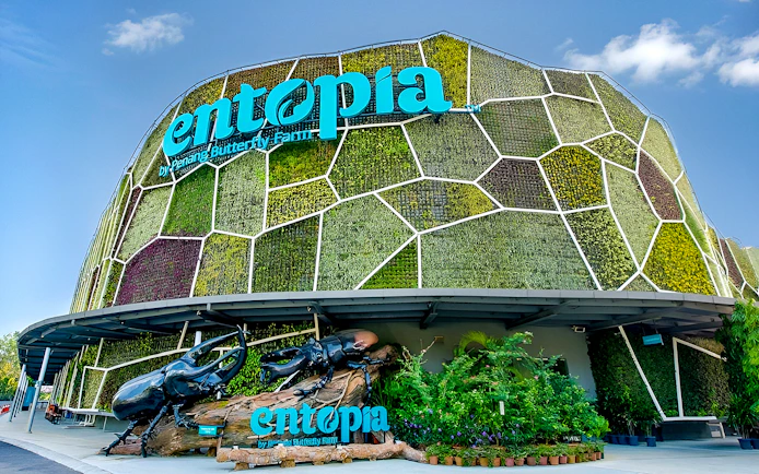 Entrance of Entopia by Penang Butterfly Farm with green wall and beetle sculpture.