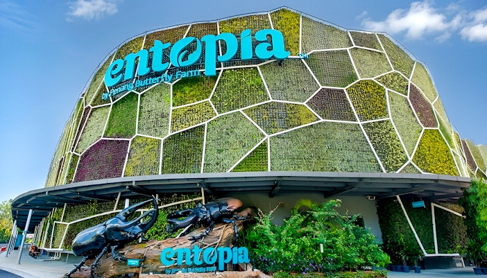 Entrance of Entopia by Penang Butterfly Farm with lush greenery and vibrant flowers.