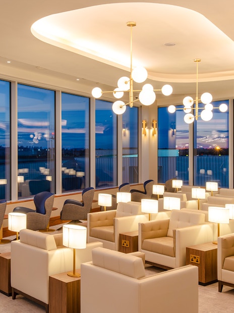 Lounge seating area at Plaza Premium Lounge, Edinburgh Airport with evening view.