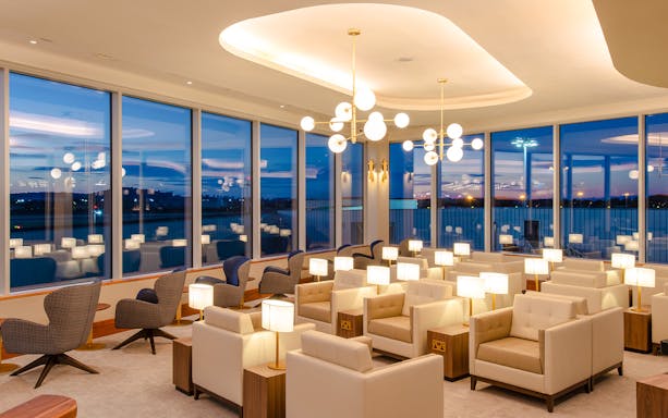 Lounge seating area at Plaza Premium Lounge, Edinburgh Airport with evening view.