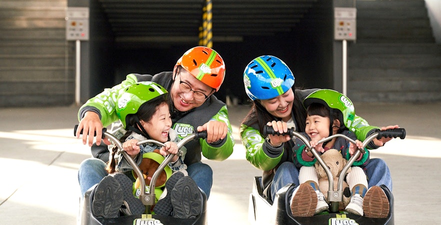 Family enjoying Skyline Luge ride in Busan.