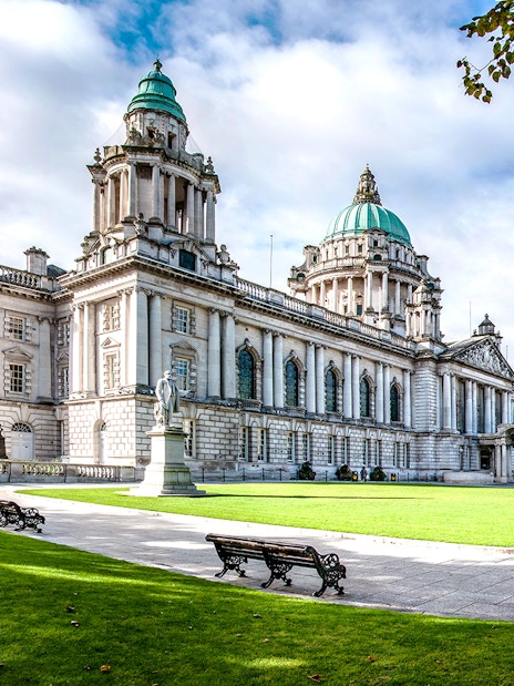 Belfast City Hall with green domes and surrounding gardens, part of Dublin to Giants Causeway tour.