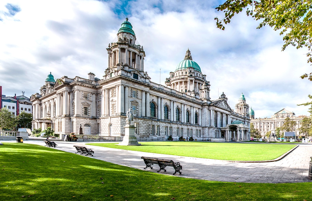 Belfast City Hall with red hop-on hop-off tour bus in front, Belfast, Northern Ireland.