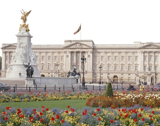 Buckingham Palace exterior with Victoria Memorial and colorful flower garden in London.