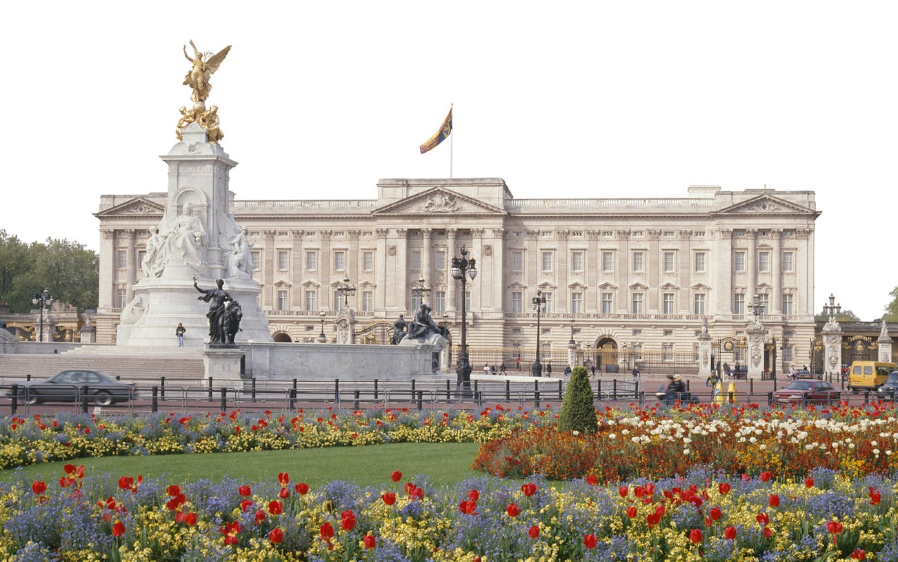 Buckingham Palace exterior with Victoria Memorial and colorful flower garden in London.