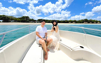 Two people relaxing on a speedboat in Sentosa, Singapore with a tropical sea backdrop.