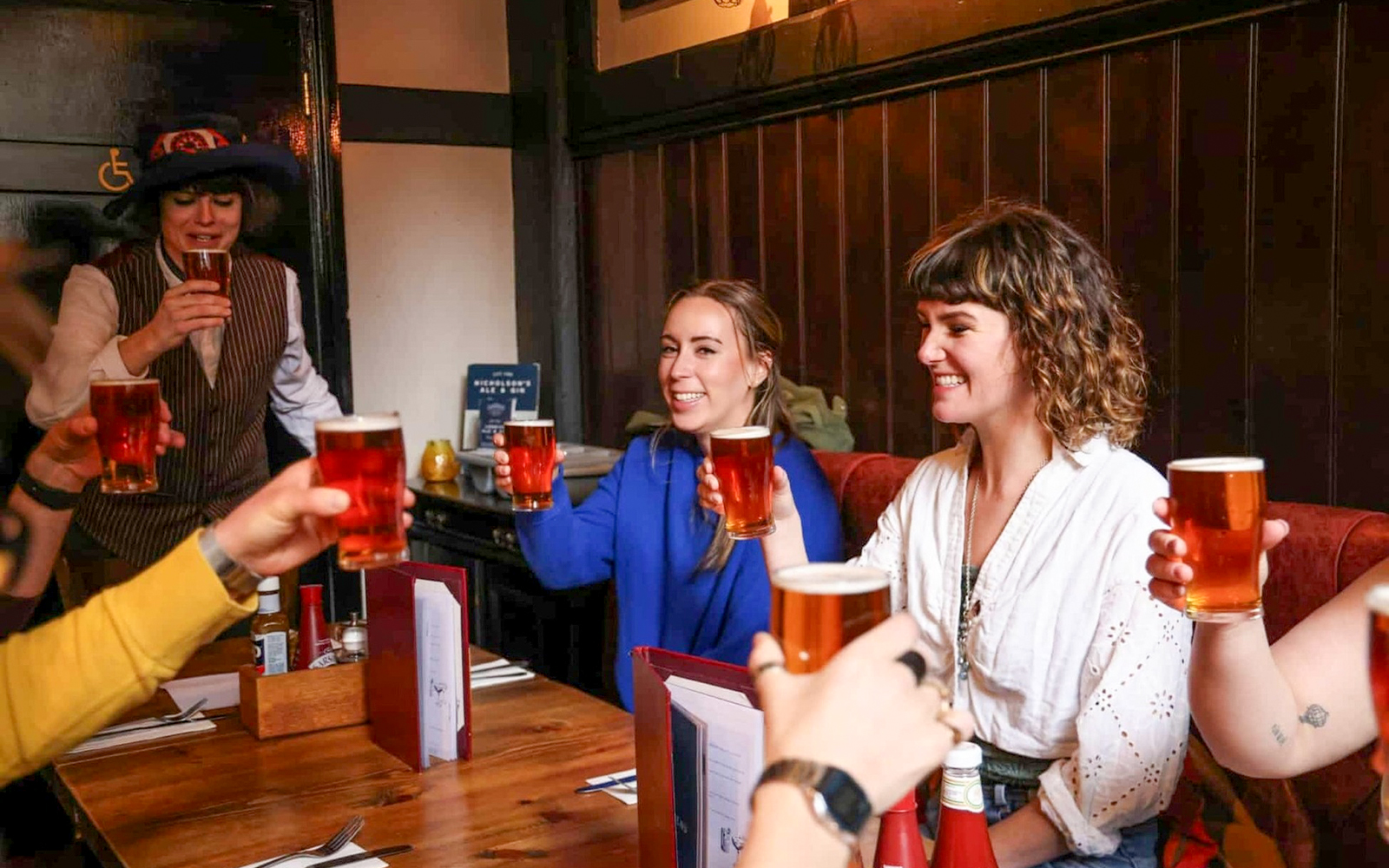 Group enjoying pints at a London pub on the Heart of 'The City' Food Tour.