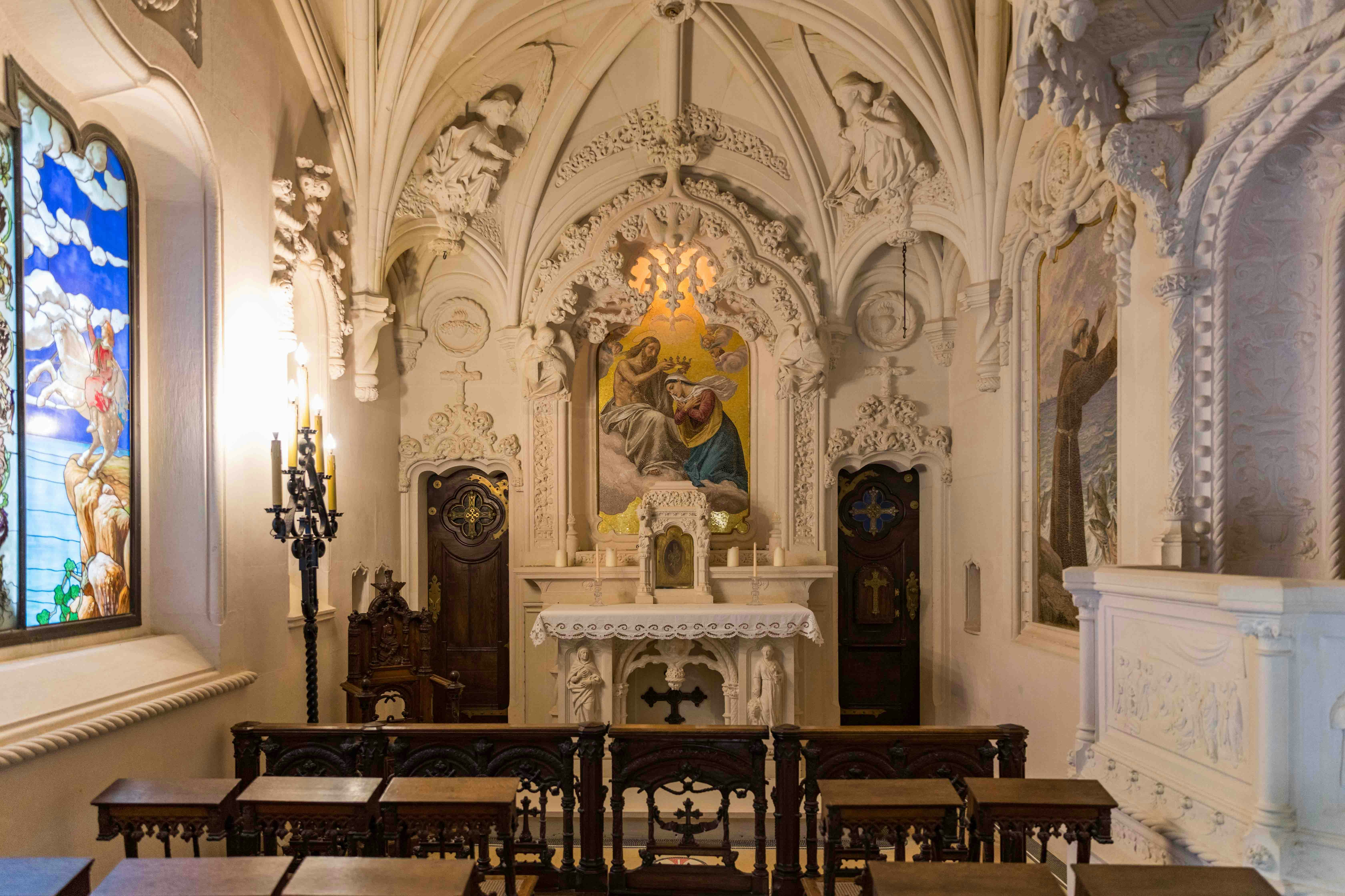 Regaleira Chapel interior with ornate altar and stained glass window in Sintra, Portugal.