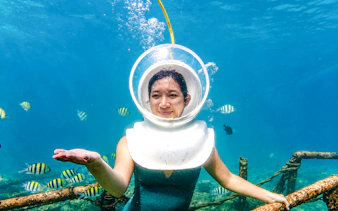 Underwater helmet diving with tropical fish in Tanjung Benoa, Bali.
