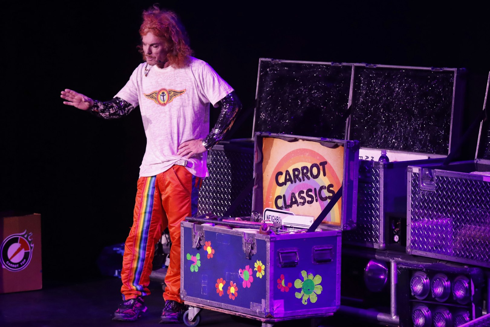 Performer on stage at Carrot Top show in Las Vegas with prop trunk labeled "Carrot Classics.