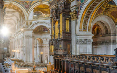 Interiors of St Paul's Cathedral in London showcasing ornate arches and detailed woodwork.