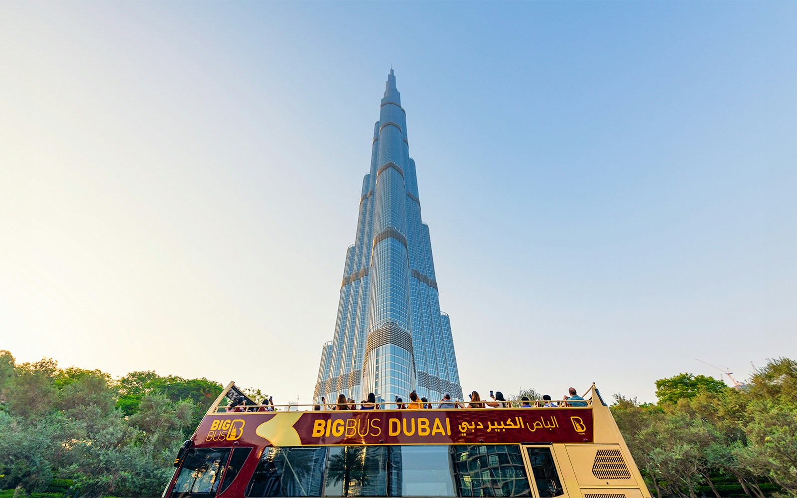 Open-top Big Bus tour in Dubai with Burj Khalifa in the background.
